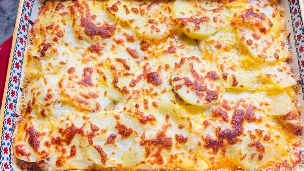 Plat de gratin doré au fromage fondu, sorti du four et posé sur une table