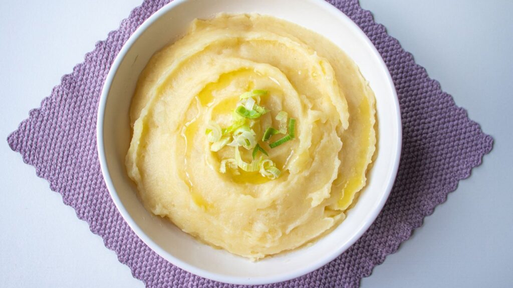 Purée de pommes de terre lissée dans une casserole avec une noix de beurre