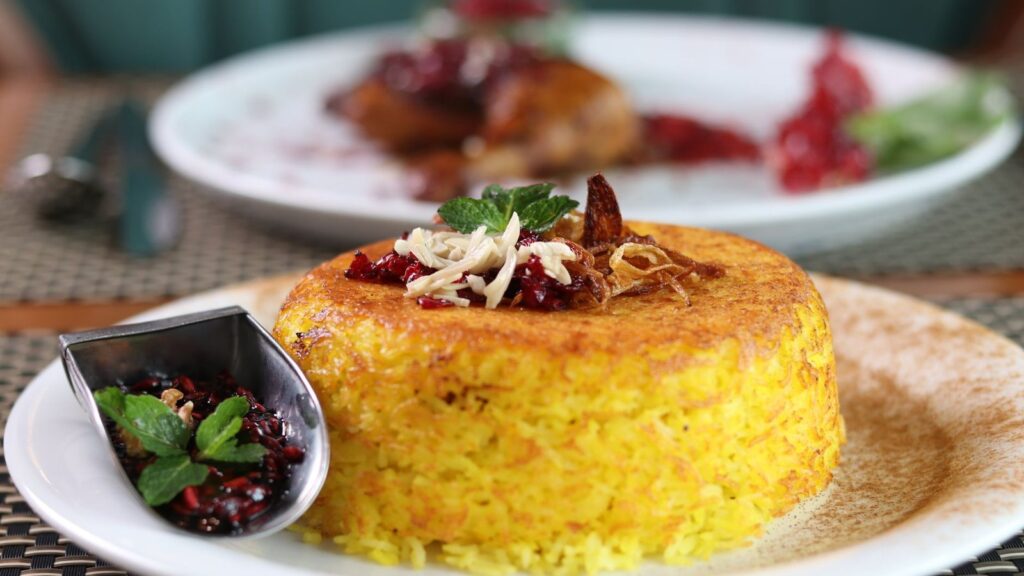 Riz jaune safrané servi en dôme, accompagné d'une petite sauce à part