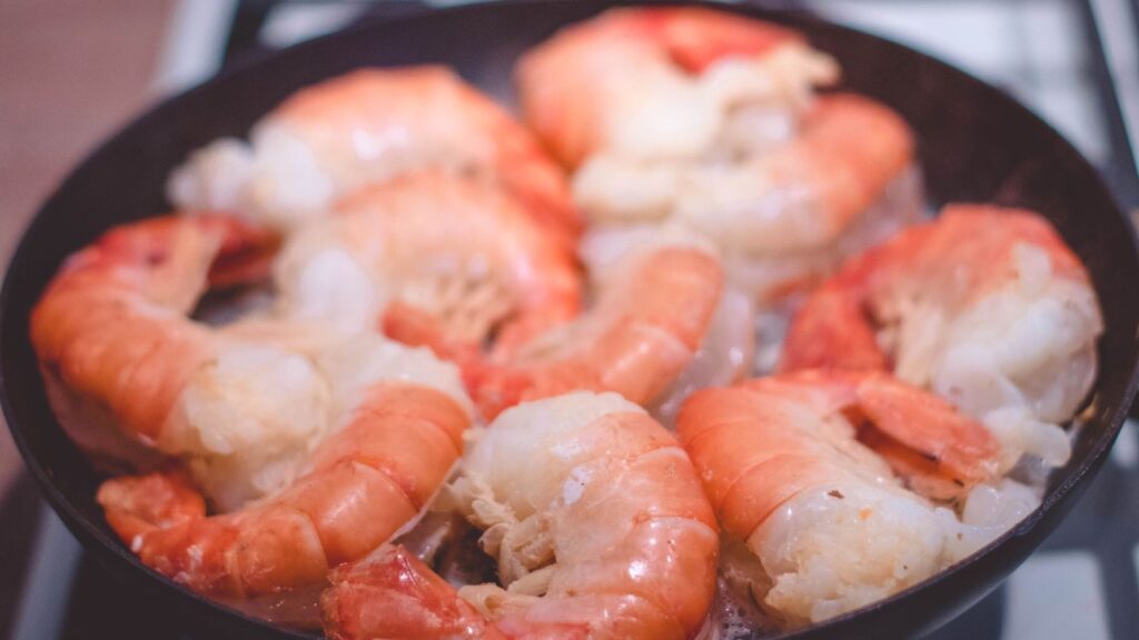 Crevettes roses posées sur du riz en fin de cuisson