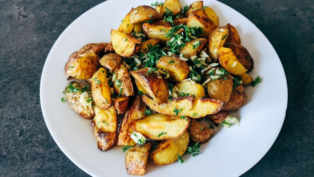 Pommes de terre rôties au persil servies dans une assiette blanche