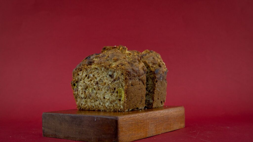 Cake sombre coupé en tranches épaisses, posé sur une planche en bois