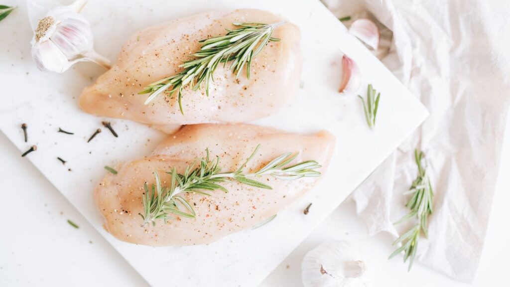 Filets de poulet crus aplatis à épaisseur égale sur une planche